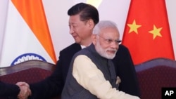 资料照片:参加在印度举行的金砖峰会的中、印领导人与其他成员国领导人握手。（2016年10月16日）