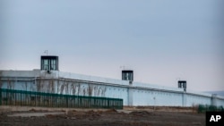 People stand in a guard tower on the perimeter wall of the Urumqi No. 3 Detention Center in Dabancheng in western China's Xinjiang Uyghur Autonomous Region on April 23, 2021. (AP Photo/Mark Schiefelbein)