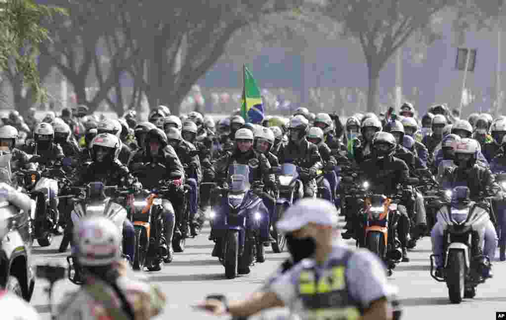 Brazil's President Jair Bolsonaro, center, takes part in a caravan of motorcycle enthusiasts in Sao Paulo, Brazil, June 12, 2021.
