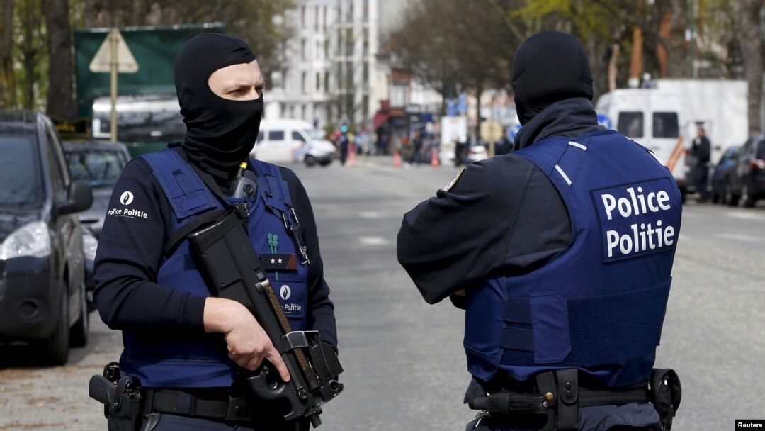 FILE - Belgium police officers secure an area during a police operation in Etterbeek, near Brussels, Belgium, April 9, 2016. 