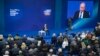 Russian President Vladimir Putin, sitting on the stage at centre rear, speaks to his supporters during a meeting for his campaign in Moscow, Jan. 30, 2018. 