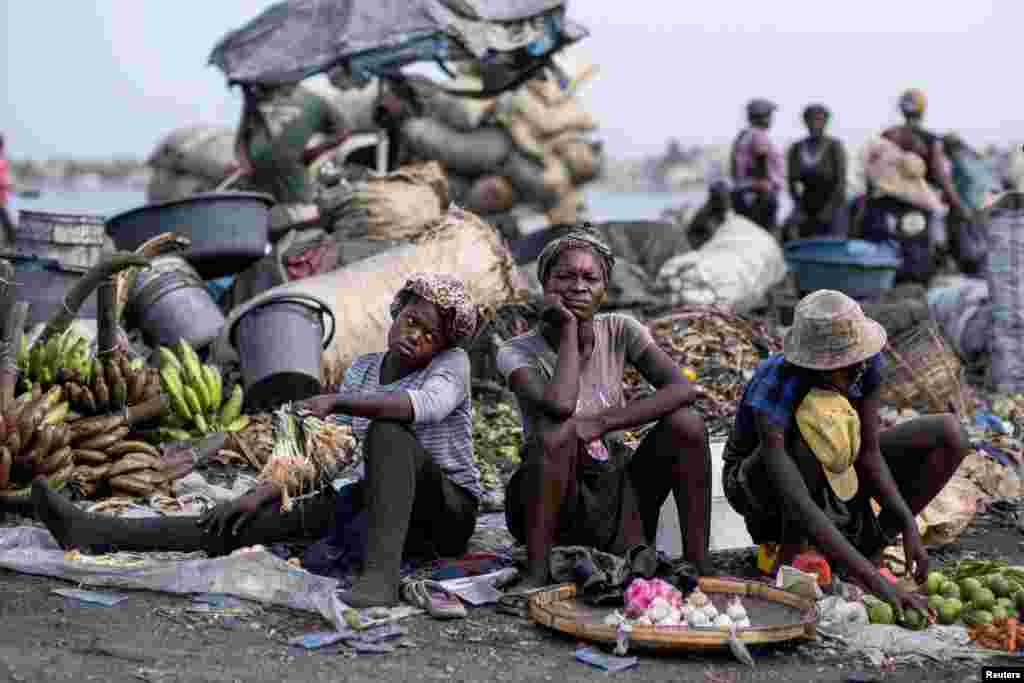 People sell fresh produce look on at a market in Cap-Haitien, Haiti, July 21, 2021.