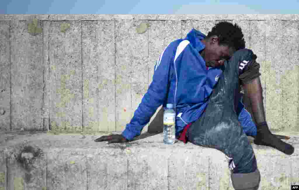 A migrant rests after arriving aboard a coast guard boat at Algecira&#39;s harbor, July 14, 2018, after an inflatable boat carrying nine migrants was rescued by the Spanish coast guard off the Spanish coast.