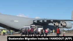 从美国被驱逐的危地马拉移民在危地马拉城空军基地走下一架美国军机。(2025年1月24日)