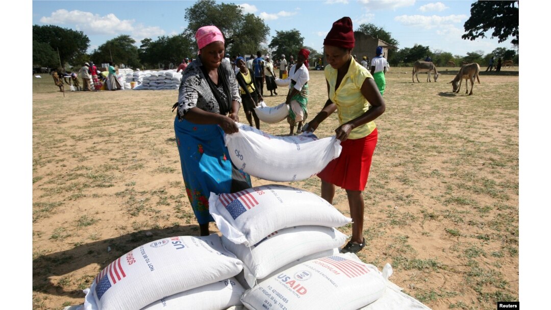 Villagers queue to collect their monthly food aid ration of cereals at a school in drought hit Masvingo, Zimbabwe, June 2, 2016.