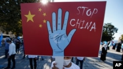 资料照片：一名来自土耳其维吾尔族社区的抗议者在伊斯坦布尔的一场抗议活动中举着反对中国的标语，抗议他们所指称的中国政府在新疆对维吾尔穆斯林的压迫。(2020年10月1日)
