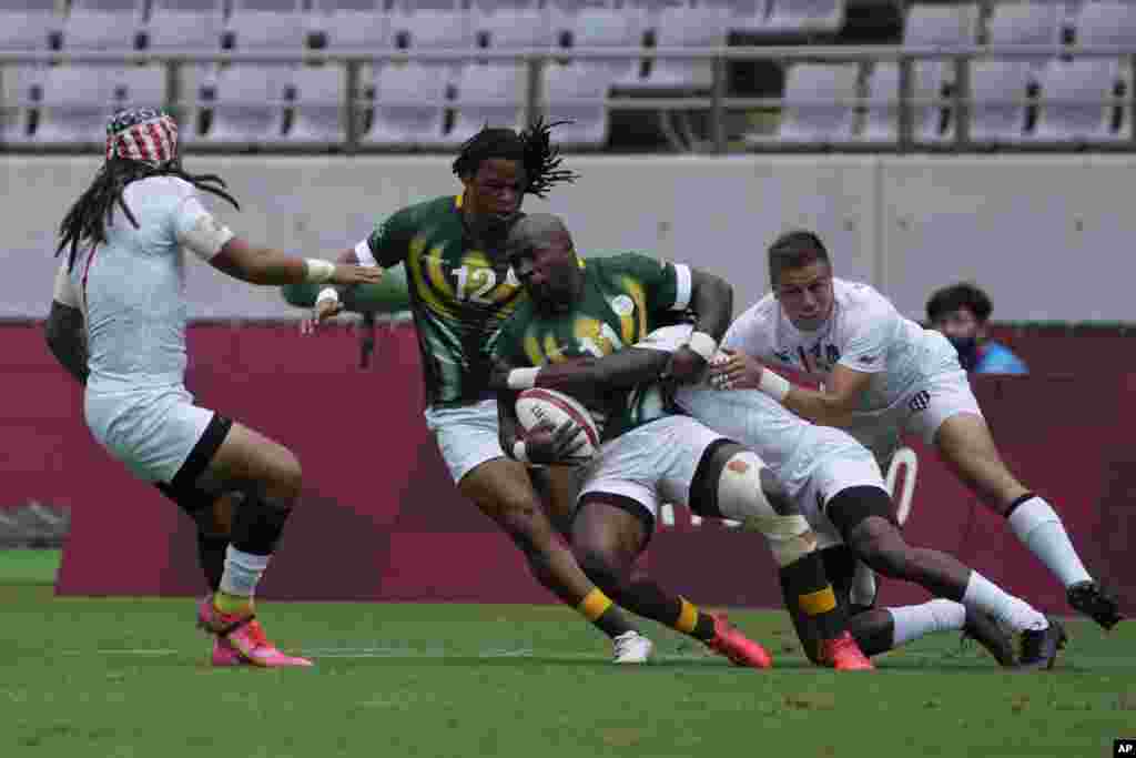 South Africa's Siviwe Soyizwapi gets tackled by Carlin Isles of the United States, in their men's rugby sevens match at the 2020 Summer Olympics, Tuesday, July 27, 2021 in Tokyo, Japan. (AP Photo/Shuji Kajiyama)