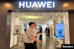 北京一家商场的华为商店展出Mate 60系列手机的广告。（2023年8月30日）