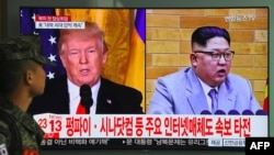 一名韩国士兵走过首尔火车站正在播放美国总统川普（左）和朝鲜领导人金正恩画面的电视屏幕。（2018年3月9日）