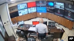 En esta imagen de vídeo -sin fecha tomada- compartida con Associated Press por un grupo de hackers que se hacen llamar La Justicia de Ali, un guardia mira las pantallas de vigilancia tomadas por el grupo, en la prisión de Evin en Teherán, Irán.