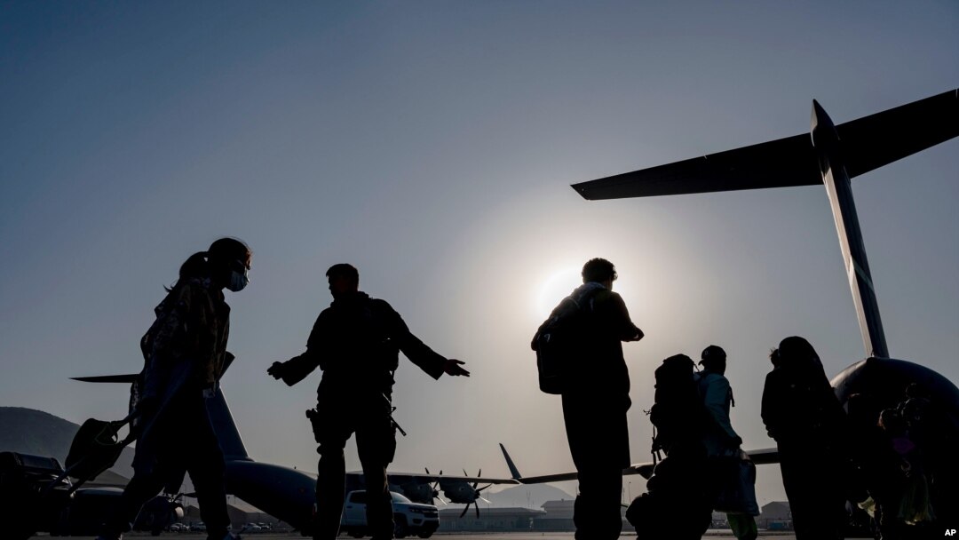 US Air Force airmen guide evacuees aboard a transport aircraft at Hamid Karzai International Airport in Kabul, Afghanistan, Aug. 24, 2021. (US Air Force photo)