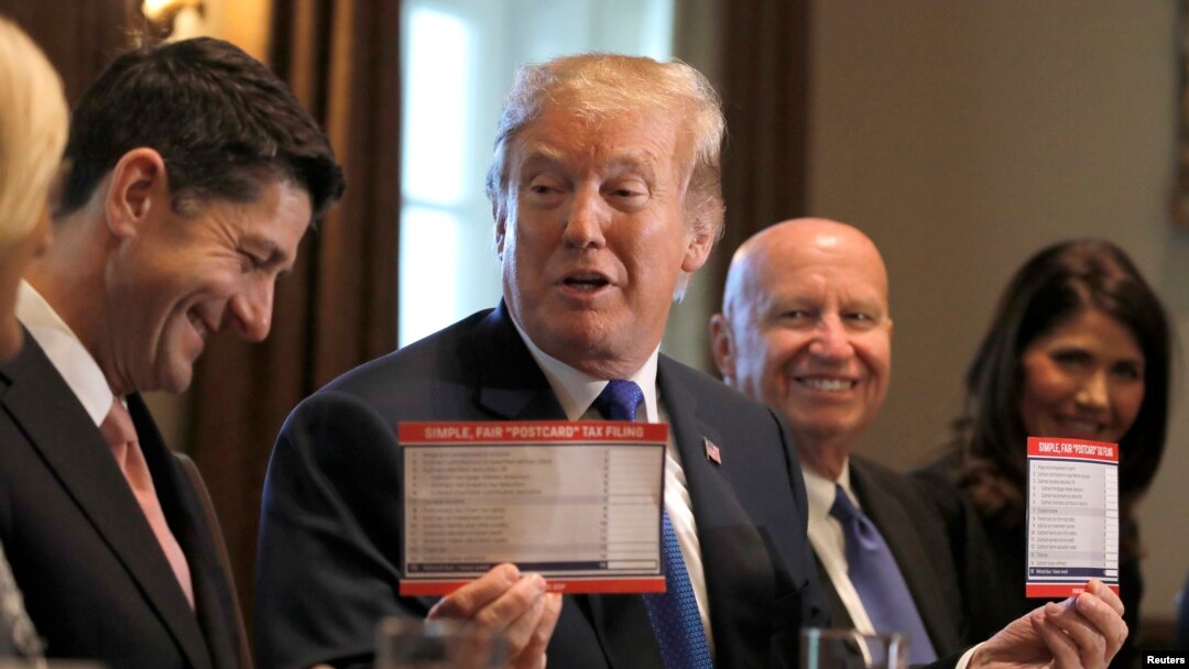 U.S. President Donald Trump holds sample tax forms as he promotes a newly unveiled Republican tax plan with House Republican leaders in the Cabinet Room of the White House in Washington, Nov. 2, 2017. 
