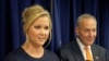 Actress Amy Schumer speaks while her distant cousin, Senator Chuck Schumer watches during a news conference in New York, Aug. 3, 2015. The Schumers are teaming up to try and enact gun control regulations. 