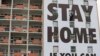 A billboard is installed on an apartment building in Cape Town, South Africa, March 25, 2020, calling on people to stay indoors to fight the spread of the new coronavirus. 