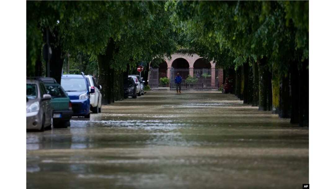 FILE - A man walks in the flooded village of Castel Bolognese, Italy, Wednesday, May 17, 2023. Exceptional rains Wednesday in a drought-struck region of northern Italy swelled rivers over their banks, killing at least eight people, forcing the evacuation of thousands and prompting officials to warn that Italy needs a national plan to combat climate change-induced flooding. (AP Photo/Luca Bruno)
