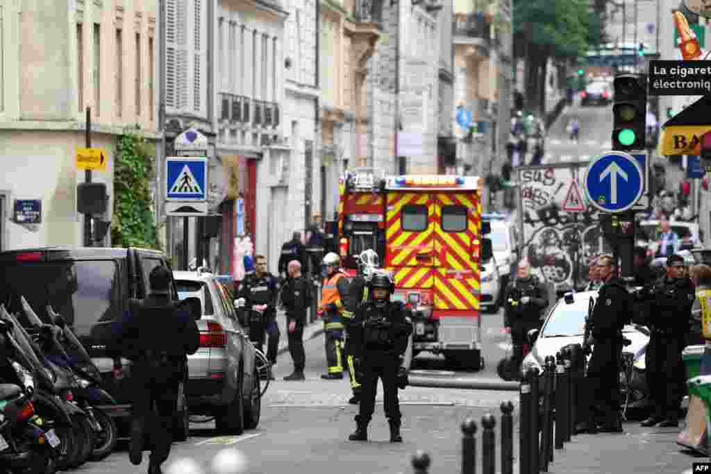 Police officers stand on a street near the site of an ongoing hostage taking in central Paris, France.