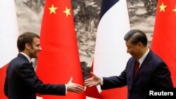 中国国家主席习近平即将对法国展开国事访问，引起法国的维吾尔人愤怒。图为去年4月法国总统马克龙访问中国。（路透社）