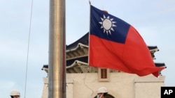 两名台湾卫兵在台北中正纪念堂自由广场举行的每日升旗仪式上降下国旗。(美联社：2023年10月10日)