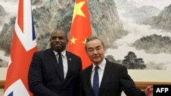 英国外交大臣戴维·拉米（左）和中国外交部长王毅于 2024 年 10 月 18 日在北京钓鱼台国宾馆会晤前握手。