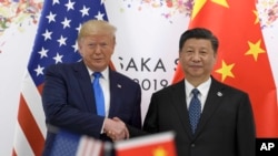 资料照：2019年6月29日，时任美国总统特朗普与中国国家主席习近平在大坂召开的G20峰会上握手。