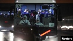 2020年2月17日钻石公主号游轮上冠状病毒测试呈阳性反应人士坐巴士离开码头。