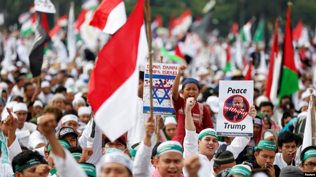 Protesters hold signs during a rally to condemn U.S. President Donald Trumps's decision to recognize Jerusalem as Israel's capital, at Monas, the national monument, in Jakarta, Indonesia, Dec. 17, 2017.
