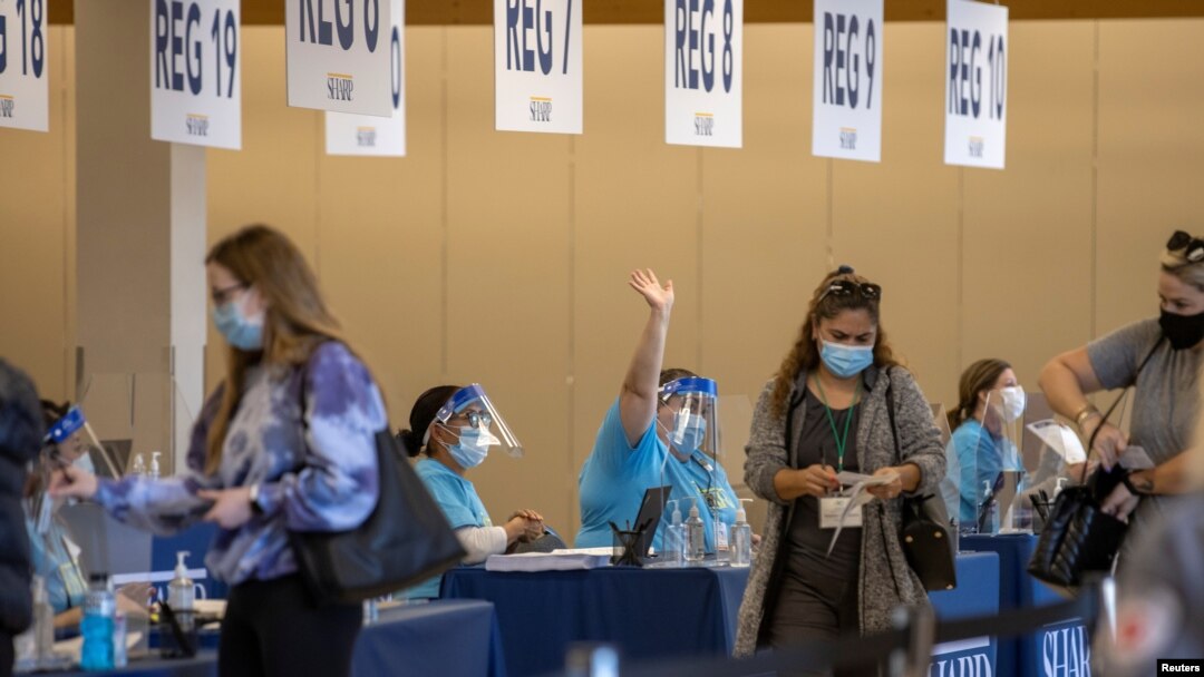 People are processed at the entrance to an empty department store being used as a vaccination center during the outbreak of the coronavirus disease (COVID-19) in Chula Vista, California, Jan. 21, 2021. 