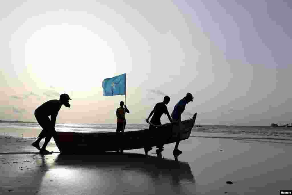Fishermen carry a boat in to the water in Lido beach, Mogadishu's Abdiaziz District, Somalia