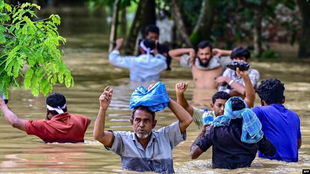 Watu wakikatiza eneo lililokumbwa na mafuriko katika mji wa Feni, kusini mashariki ya Bangladesh, Agosti 24, 2024.