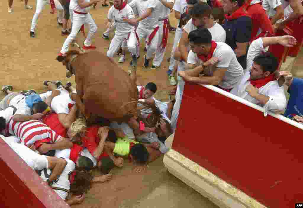 A bull jumps over revelers at the bullring during festivities of the San Fermin festival in Pamplona, northern Spain.