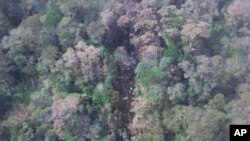 Esta foto divulgada por la Agencia Nacional de Búsqueda y Rescate de Indonesia, el lunes, 17 de agosto de 2015, muestra parte de los restos del avión de Trigana Air que se estrelló en Oksvil, Papúa, Indonesia.