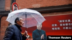 "两会“召开前夕，一名男子在上海街头一幅有习近平像的宣传板前走过。