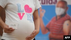 2021年7月23日，一怀孕女子在哥伦比亚波哥大一疫苗接种中心接受了辉瑞疫苗接种之后拿到了接种卡。