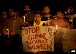 FILE - Indian youth hold candles during a protest against sexual violence in New Delhi, Feb. 9, 2015.