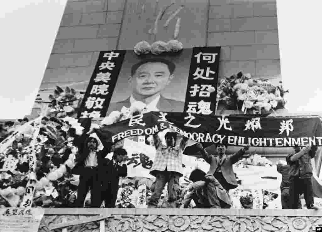 中国学生在北京天安门广场上的人民英雄纪念碑前展示胡耀邦像和“民主之光耀邦”等标语(1989年4月19日) 。1989年4月15日,抑郁中的胡耀邦突然心梗病逝,引发民众不满和自发悼念,直接触发后来的八九民运和“六四事件”。而这也导致胡耀邦多年来成为中共党内的禁忌,直到团派出身的前总书记胡锦涛任内才逐渐解禁,并于2015年11月20日为他举办百岁诞辰座谈会。