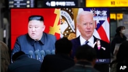 资料照片：韩国首尔的民众在一个火车站内观看美国与朝鲜问题的电视节目（2021年3月26日）