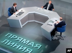 The words on the floor read: "Direct Line" as President Vladimir Putin, center, attends his annual call-in show in Moscow, Russia, June 7, 2018.