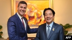 资料照：2023年8月14日，台湾时任副总统赖清德在访问巴拉圭期间与时任巴拉圭当选总统圣地亚哥·潘尼亚（Santiago Pena）左）握手。