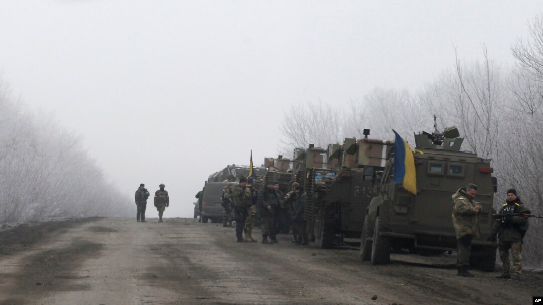 FILE - Ukrainian military convoy stops between the towns of Dabeltseve and Artemivsk, Feb. 14, 2015.