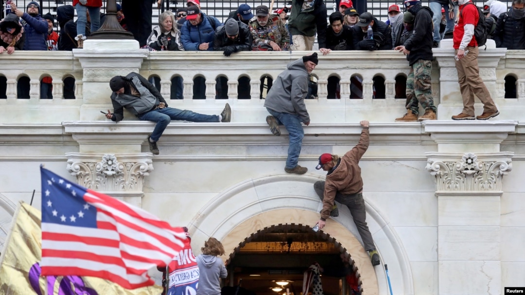 FILE - A mob of supporters of U.S. President Donald Trump fight with members of law enforcement at a door they broke open as they storm the U.S. Capitol Building in Washington, Jan. 6, 2021. 