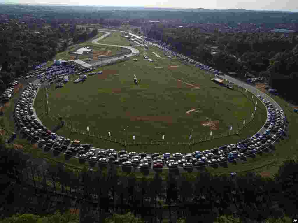 People line up at a drive-thru vaccination center at the Ruben Dumot Autodrome for Pfizer's COVID-19 vaccine in Capiata, Paraguay.