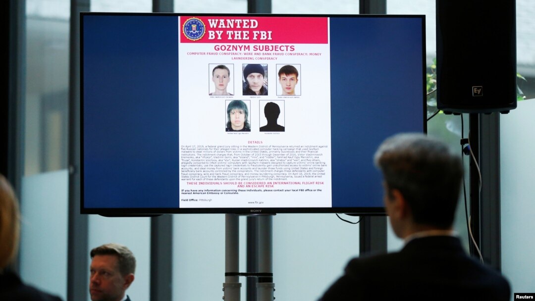 Suspects of cybercrime are seen on the screen at the news conference to announce a major law enforcement action against a transnational organized cybercrime at the Europol's headquarters in The Hague, Netherlands, May 16, 2019. 