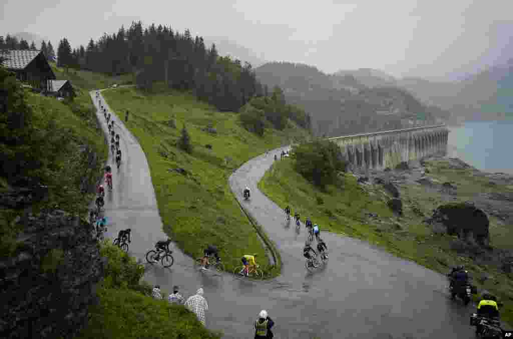 The group with Slovenia's Tadej Pogacar, wearing the overall leader's yellow jersey, rides towards Cormet de Roselend pass during the ninth stage of the Tour de France cycling race over 144.9 kilometers (90 miles) with start in Cluses and finish in Tignes, France.