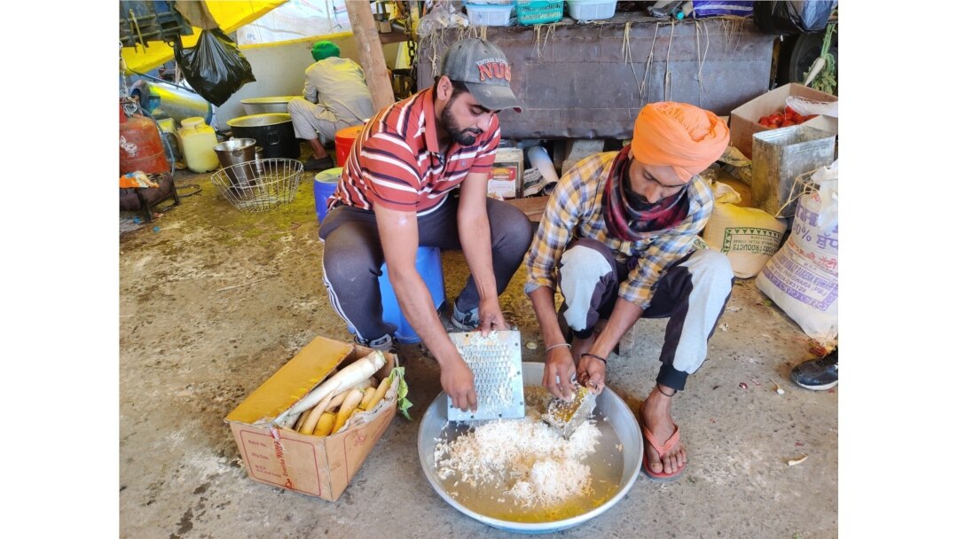 Manveer Singh, a postgraduate, helps prepare a community meal for protesters in India. (A. Pasricha/VOA)