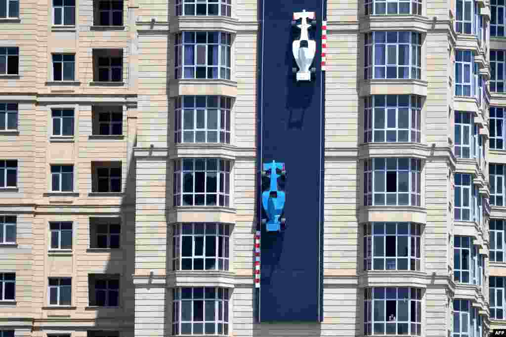 Artwork depicting race cars on the track is seen on the wall of a building during the first practice session of the Formula One Azerbaijan Grand Prix at the Baku City Circuit.