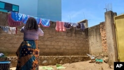 FILE - Reby hangs laundry outside her home in Beni, eastern Congo, May 1, 2021. Reby says Dr. Boubacar Diallo of the World Health Organization offered her money for sex.