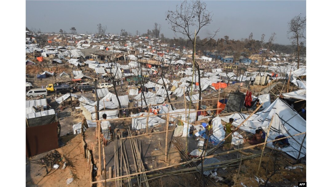 FILE - Rohingya refugee men build a temporary shelter days after a fire burnt their home at a refugee camp in Ukhia, in the southeastern Cox's Bazar district, March 25, 2021.