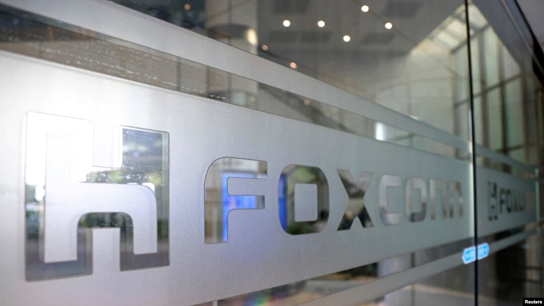 FILE - Foxconn signage is seen on a glass door inside the company's office building in Taipei, Taiwan, Nov. 12, 2020.