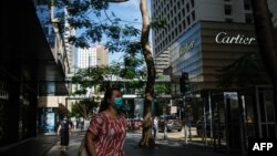 行人佩戴口罩走过香港中环的街道。（2020年7月16日）