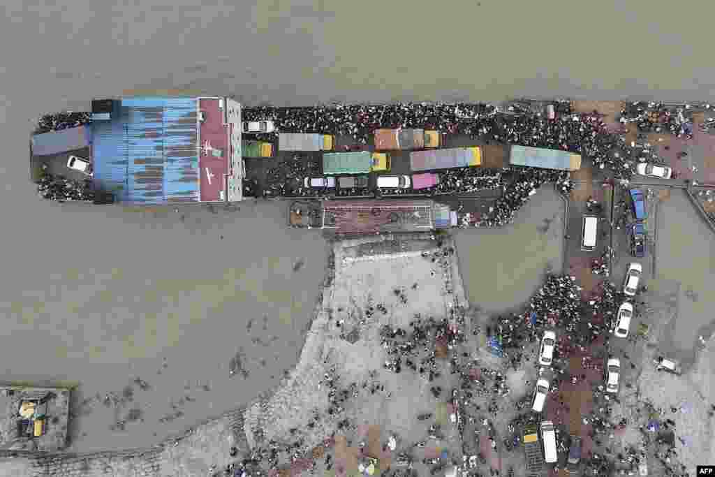 This aerial photo shows people board a ferry as authorities order a new lockdown to contain the spread of the Covid-19 coronavirus, in Munshiganj, Bangladesh.